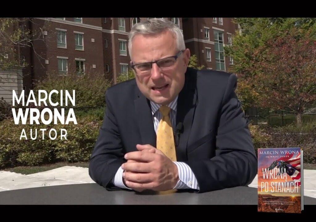 Marcin Wrona, dziennikarz TVN, relacjonujący wydarzenia z mikrofonem w ręku.
