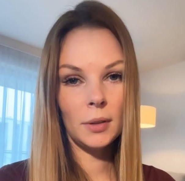 Alt: Małgorzata Tomaszewska w dynamicznej pozie na planie telewizyjnym, podczas prowadzenia programu.