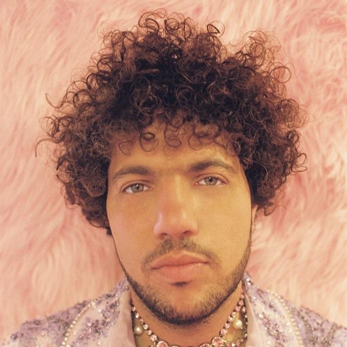 Benny Blanco w studiu nagraniowym, skupiony na pracy przy konsolecie, w otoczeniu instrumentów.