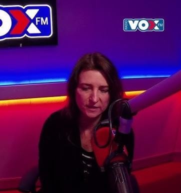 Renata Dąbkowska występuje na scenie z zespołem, w tle światła reflektorów.