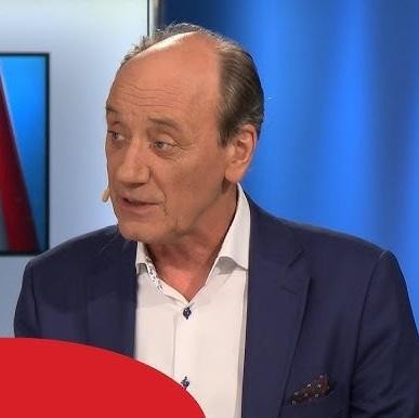 Dariusz Szpakowski, polski komentator sportowy, z mikrofonem w dłoni, w trakcie komentowania meczu.