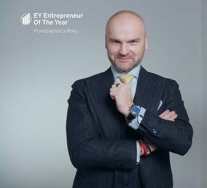 Rafał Brzoska podczas uprawiania sportu ekstremalnego, np. w kokpicie samolotu wojskowego lub na górskim szlaku.