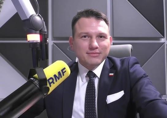 Sławomir Mentzen podczas wystąpienia publicznego, z gestykulacją i wyraźną mimiką, w tle zamazany tłum lub wnętrze sali sejmowej.