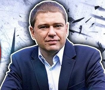 Piotr Szumlewicz przemawiający na wiecu lub debacie, z pasją gestykulujący, co symbolizuje jego zaangażowanie w sprawy społeczne i prawa pracownicze.