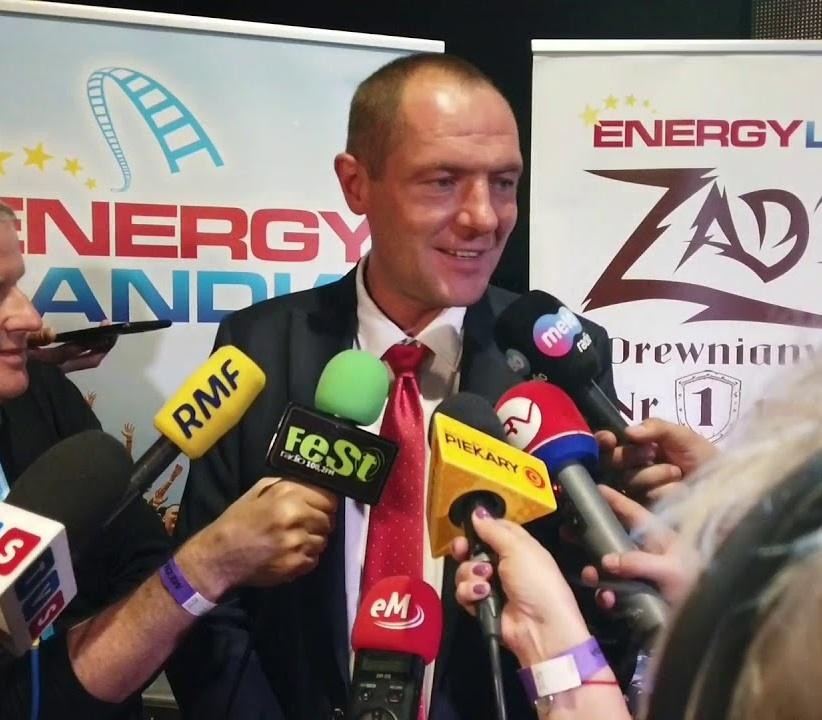 Alt: Panoramiczny widok na park rozrywki Energylandia o zmierzchu, ukazujący jego oświetlone atrakcje i tętniącą życiem atmosferę.