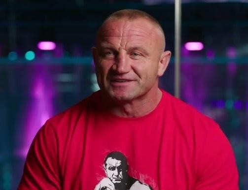 Mariusz Pudzianowski podczas intensywnego treningu, prezentujący swoją siłę i determinację w siłowni.